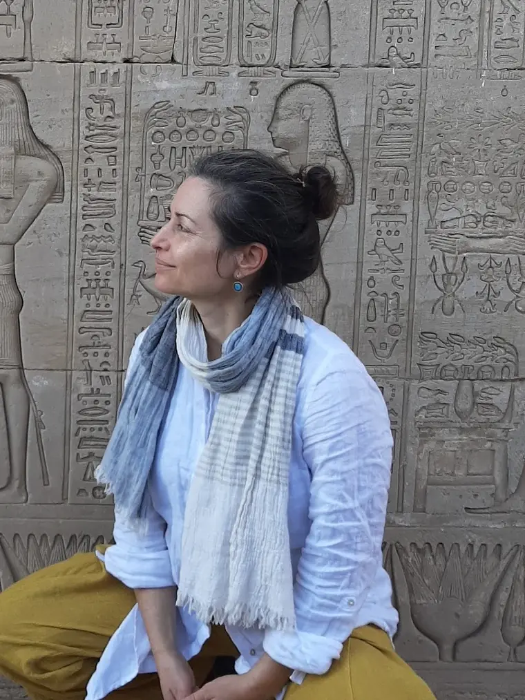 Portrait of Liat in front of a hieroglyphic temple wall.